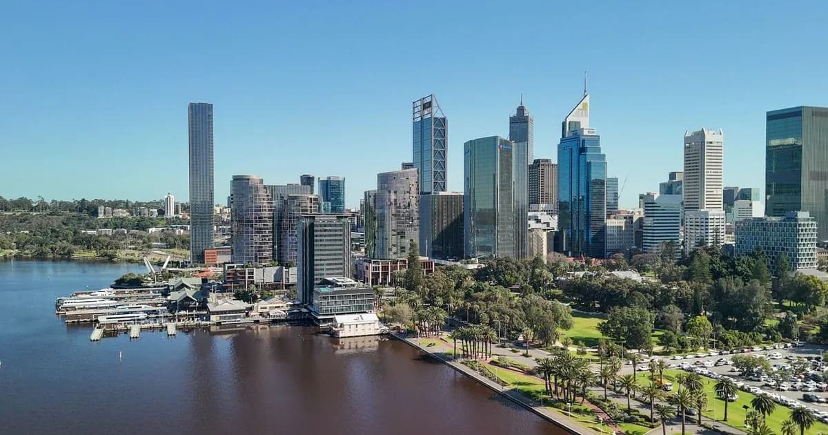 Perth skyline with high-rise buildings overlooking the Swan River, featuring parks and green spaces along the waterfront.